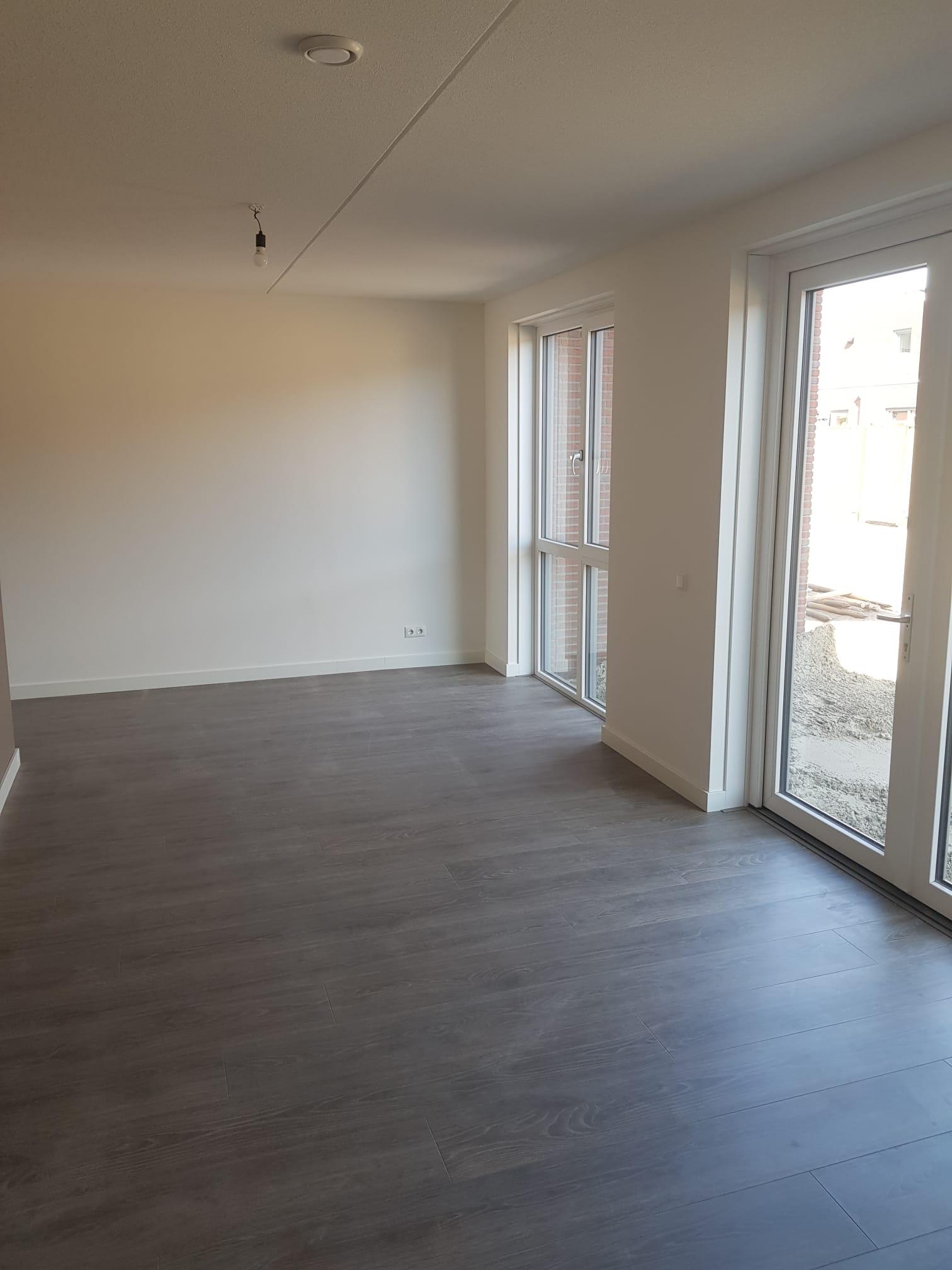 Laminaatvloer in een lege kamer met openslaande tuindeuren