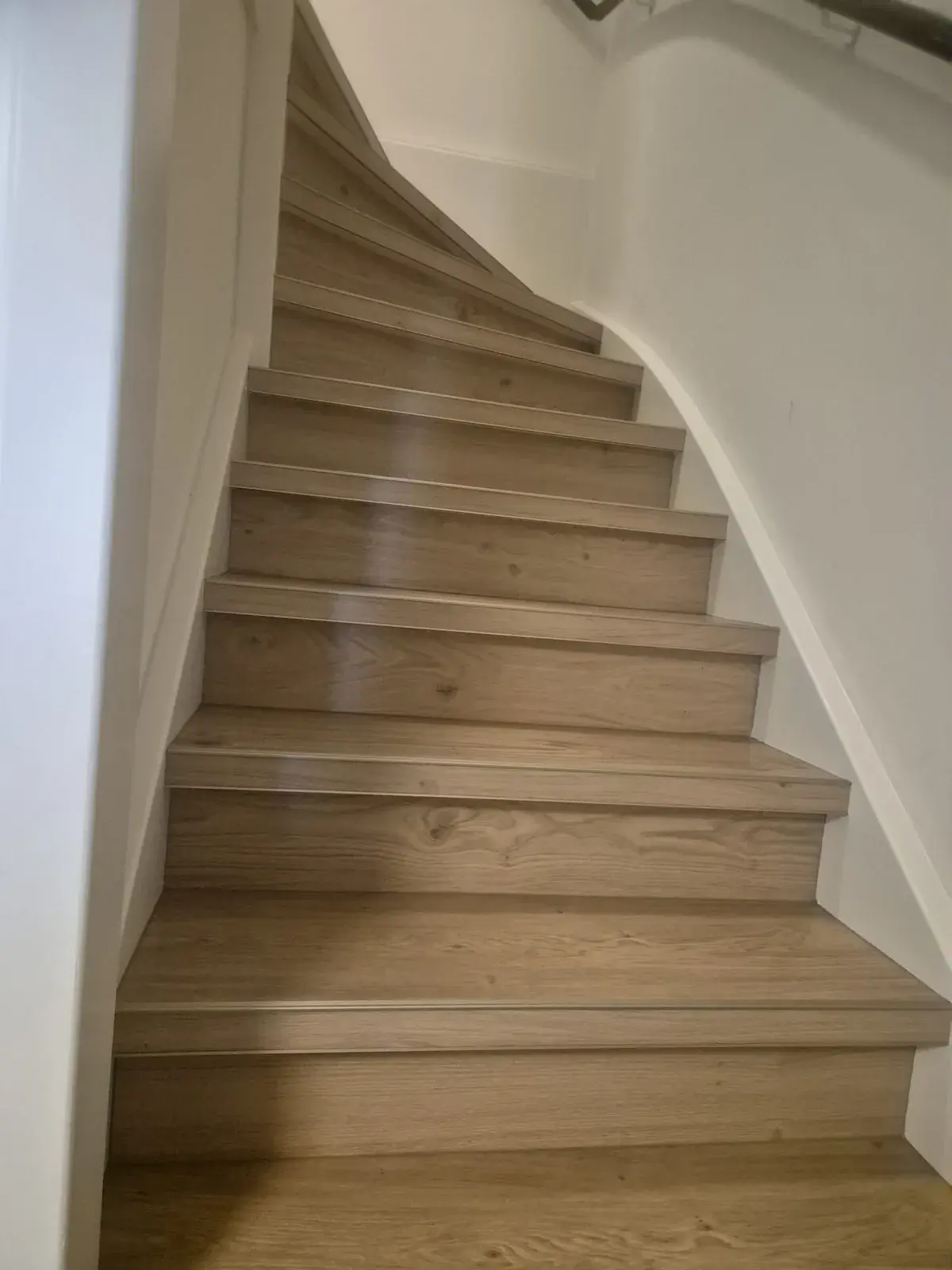 Draaiende trap in Tiel, bekleed met pvc in houtlook